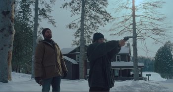 Movie still from “The Lodge” (2019), directed by Severin Fiala – Two men standing in the snow with a gun; Wide shot, Low angle
