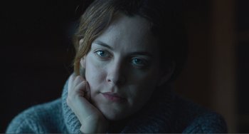 Movie still from “The Lodge” (2019), directed by Severin Fiala – A person with a hand on her chin; Close Up shot, Over the shoulder angle