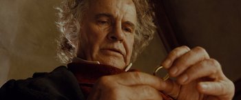 Movie still from “The Lord of the Rings: The Fellowship of the Ring” (2001), directed by Peter Jackson – An older man holding a pair of scissors in his hand; Close Up shot, Over the shoulder angle