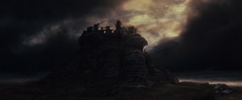 Movie still from “The Lord of the Rings: The Fellowship of the Ring” (2001), directed by Peter Jackson – A dark sky with a castle on top of a hill; Extreme Wide shot, Low angle