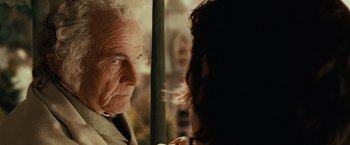Movie still from “The Lord of the Rings: The Fellowship of the Ring” (2001), directed by Peter Jackson – An older man and a younger woman looking at each other; Close Up shot, Over the shoulder angle