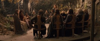Movie still from “The Lord of the Rings: The Fellowship of the Ring” (2001), directed by Peter Jackson – A group of people sitting in chairs in a circle; Wide shot, High angle
