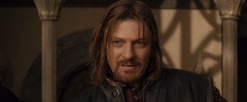 Movie still from “The Lord of the Rings: The Fellowship of the Ring” (2001), directed by Peter Jackson – A person with long hair and a beard; Close Up shot, Over the shoulder angle