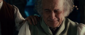 Movie still from “The Lord of the Rings: The Fellowship of the Ring” (2001), directed by Peter Jackson – An old man with a white beard is holding his shoulder; Close Up shot, Over the shoulder angle