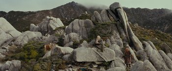 Movie still from “The Lord of the Rings: The Fellowship of the Ring” (2001), directed by Peter Jackson – An old man sitting on top of a mountain; Extreme Wide shot, High angle