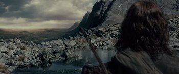 Movie still from “The Lord of the Rings: The Fellowship of the Ring” (2001), directed by Peter Jackson – A stick in the middle of a lake near a mountain; Extreme Wide shot, High angle