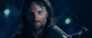Movie still from “The Lord of the Rings: The Fellowship of the Ring” (2001), directed by Peter Jackson – A person with long hair and a beard; Close Up shot, Over the shoulder angle