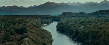 Movie still from “The Lord of the Rings: The Fellowship of the Ring” (2001), directed by Peter Jackson – A view of a body of water with mountains in the background; Extreme Wide shot, High angle