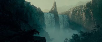 Movie still from “The Lord of the Rings: The Fellowship of the Ring” (2001), directed by Peter Jackson – A waterfall in the middle of a valley with mountains in the background; Extreme Wide shot, Low angle