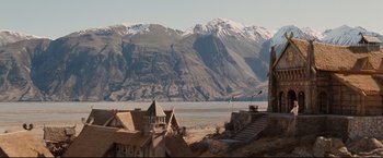 Movie still from “The Lord of the Rings: The Return of the King” (2003), directed by Peter Jackson – A view of a mountain range with a lake in the background; Extreme Wide shot, High angle