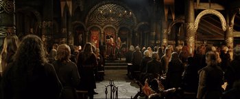 Movie still from “The Lord of the Rings: The Return of the King” (2003), directed by Peter Jackson – A group of people sitting in front of a stage; Wide shot, High angle