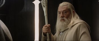 Movie still from “The Lord of the Rings: The Return of the King” (2003), directed by Peter Jackson – An older man holding a white staff in his hand; Close Up shot, Low angle
