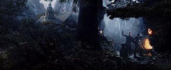 Movie still from “The Lord of the Rings: The Return of the King” (2003), directed by Peter Jackson – A dark forest with trees and a house in the background; Extreme Wide shot, High angle