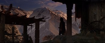 Movie still from “The Lord of the Rings: The Return of the King” (2003), directed by Peter Jackson – A person standing on top of a hill with a mountain in the background; Wide shot, Low angle
