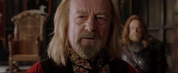 Movie still from “The Lord of the Rings: The Return of the King” (2003), directed by Peter Jackson – An older man with long blonde hair and a beard; Close Up shot, Low angle