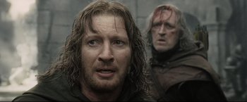 Movie still from “The Lord of the Rings: The Return of the King” (2003), directed by Peter Jackson – Two men with long hair and one is wearing a wig; Close Up shot, Over the shoulder angle