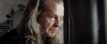 Movie still from “The Lord of the Rings: The Return of the King” (2003), directed by Peter Jackson – An older man with long grey hair stares into the distance; Close Up shot, Over the shoulder angle