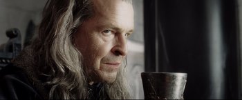 Movie still from “The Lord of the Rings: The Return of the King” (2003), directed by Peter Jackson – An older man with long grey hair and blue eyes looking into the distance; Close Up shot, Over the shoulder angle