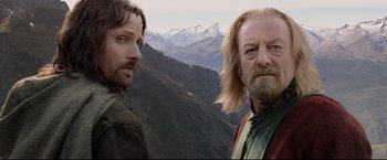 Movie still from “The Lord of the Rings: The Return of the King” (2003), directed by Peter Jackson – Two men standing next to each other on top of a mountain; Close Up shot, Low angle
