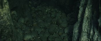 Movie still from “The Lord of the Rings: The Return of the King” (2003), directed by Peter Jackson – A pile of human skulls in a dark room; Extreme Wide shot, Overhead angle