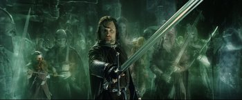 Movie still from “The Lord of the Rings: The Return of the King” (2003), directed by Peter Jackson – A man holding a sword in front of a group of people; Medium shot, Low angle