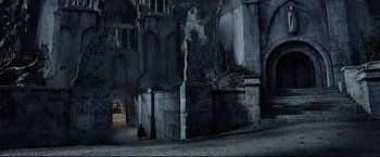 Movie still from “The Lord of the Rings: The Return of the King” (2003), directed by Peter Jackson – A person is walking in a dark alleyway; Extreme Wide shot, High angle