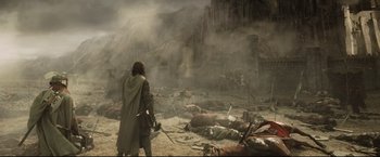 Movie still from “The Lord of the Rings: The Return of the King” (2003), directed by Peter Jackson – A man is walking through the ruins of a destroyed city; Wide shot, High angle