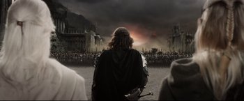 Movie still from “The Lord of the Rings: The Return of the King” (2003), directed by Peter Jackson – A crowd of people standing in front of a castle; Wide shot, Over the shoulder angle