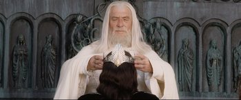 Movie still from “The Lord of the Rings: The Return of the King” (2003), directed by Peter Jackson – An old man sitting in a chair holding a crown; Close Up shot, High angle