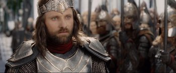 Movie still from “The Lord of the Rings: The Return of the King” (2003), directed by Peter Jackson – Aragorn in armor with other people in the background; Close Up shot, Over the shoulder angle