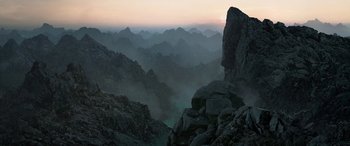 Movie still from “The Lord of the Rings: The Two Towers” (2002), directed by Peter Jackson – A view of a mountain range from the top of a cliff; Extreme Wide shot, High angle