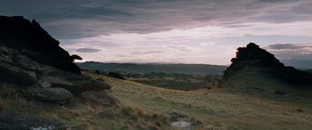 Movie still from “The Lord of the Rings: The Two Towers” (2002), directed by Peter Jackson – A view of a grassy field with mountains in the background; Extreme Wide shot, High angle