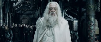 Movie still from “The Lord of the Rings: The Two Towers” (2002), directed by Peter Jackson – An old man dressed in a white outfit and white beard; Medium shot, High angle