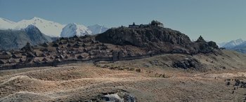 Movie still from “The Lord of the Rings: The Two Towers” (2002), directed by Peter Jackson – A mountain range with snow on the top of it; Extreme Wide shot, High angle