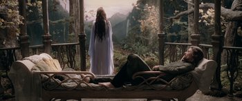 Movie still from “The Lord of the Rings: The Two Towers” (2002), directed by Peter Jackson – A woman in a white dress standing next to a bed; Wide shot, High angle