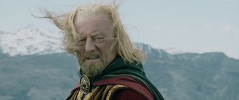 Movie still from “The Lord of the Rings: The Two Towers” (2002), directed by Peter Jackson – An older man with long blonde hair and a beard; Close Up shot, Low angle