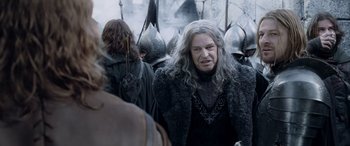 Movie still from “The Lord of the Rings: The Two Towers” (2002), directed by Peter Jackson – A man with long grey hair in a crowd of people; Close Up shot, Over the shoulder angle