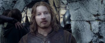 Movie still from “The Lord of the Rings: The Two Towers” (2002), directed by Peter Jackson – A person with long brown hair and a beard; Close Up shot, Over the shoulder angle