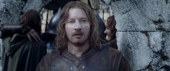 Movie still from “The Lord of the Rings: The Two Towers” (2002), directed by Peter Jackson – A person with long brown hair; Close Up shot, Over the shoulder angle