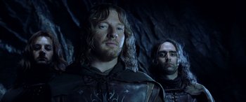 Movie still from “The Lord of the Rings: The Two Towers” (2002), directed by Peter Jackson – Two men standing next to each other in front of a wall; Close Up shot, Low angle