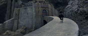 Movie still from “The Lord of the Rings: The Two Towers” (2002), directed by Peter Jackson – Two people are riding horses down a stone path; Extreme Wide shot, High angle