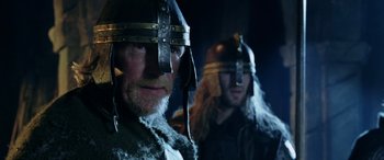 Movie still from “The Lord of the Rings: The Two Towers” (2002), directed by Peter Jackson – Two men in viking helmets are posing for a picture; Close Up shot, Low angle