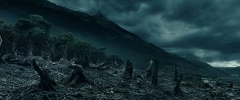 Movie still from “The Lord of the Rings: The Two Towers” (2002), directed by Peter Jackson – A dark landscape with trees and a mountain in the background; Extreme Wide shot, High angle