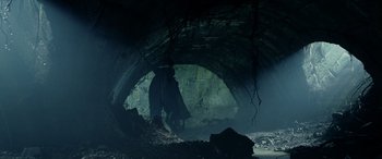 Movie still from “The Lord of the Rings: The Two Towers” (2002), directed by Peter Jackson – A person standing in a cave with a cave in the background; Wide shot, Low angle