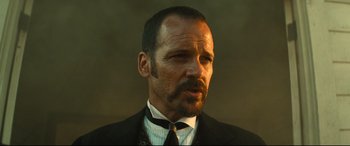 Movie still from “The Magnificent Seven” (2016), directed by Antoine Fuqua – A person wearing a suit and tie; Close Up shot, Low angle
