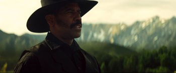 Movie still from “The Magnificent Seven” (2016), directed by Antoine Fuqua – A man in a cowboy hat looking out over a valley; Close Up shot, Low angle