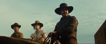 Movie still from “The Magnificent Seven” (2016), directed by Antoine Fuqua – A man and a woman sitting on top of a horse; Medium shot, Low angle