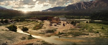 Movie still from “The Magnificent Seven” (2016), directed by Antoine Fuqua – A group of people riding horses on a dirt road; Extreme Wide shot, High angle