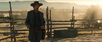 Movie still from “The Magnificent Seven” (2016), directed by Antoine Fuqua – A man with a gun standing next to a wooden fence; Medium shot, Low angle