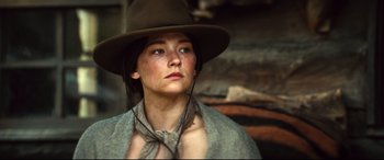 Movie still from “The Magnificent Seven” (2016), directed by Antoine Fuqua – A woman with a hat and a scarf around her neck; Close Up shot, Low angle